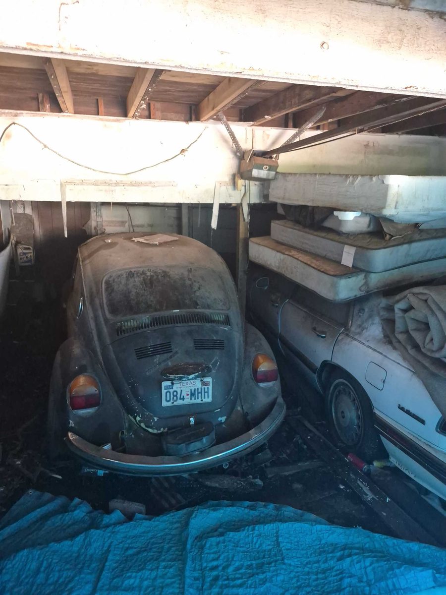 Garage packed to the ceiling around an old VW Beetle before a cleanout