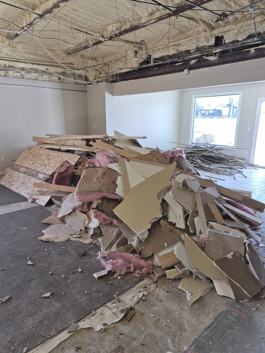 Stripped drywall and framing piled in a commercial interior demolition