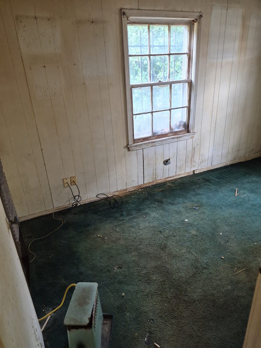 Paneled room with the carpet pulled out during an interior demo