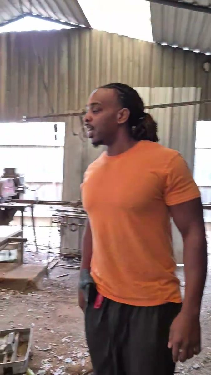 Munachi inspecting a derelict metal building before tear-out