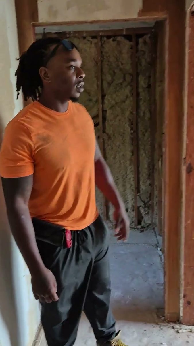 Munachi inside a room stripped to the studs