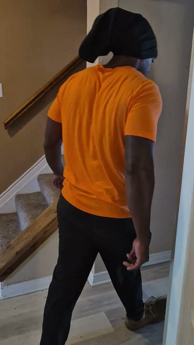 Munachi walking through a home mid-flooring tear-out