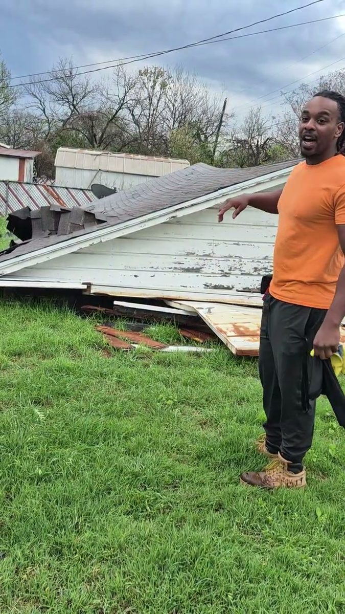 Munachi beside a collapsed outbuilding after a storm